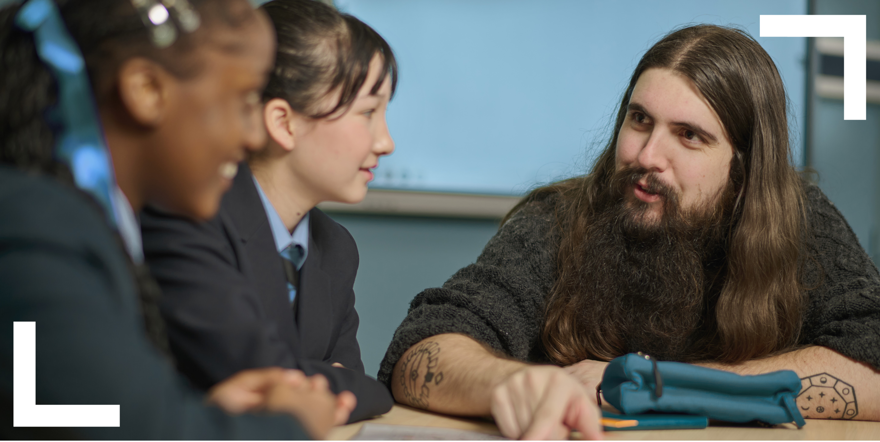 teacher talking to two teenage pupils